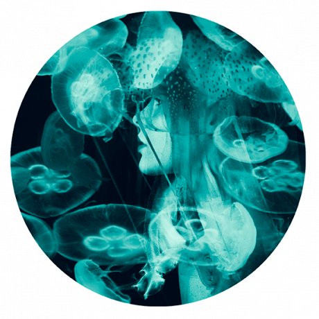 Mujer con medusas en el mar con tonos azules
