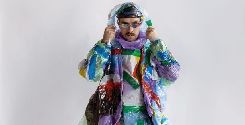 Close up of man wearing plastic on white background. Male model in clothes made of garbage. Fashion, style, recycling, eco and environmental concept. Too much pollution, we're eating and taking it.